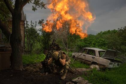 Un soldado ucraniano dispara un mortero contra posiciones rusas en la línea del frente cerca de Bajmut, región de Donetsk, Ucrania, el domingo 28 de mayo de 2023. (Foto AP/Efrem Lukatsky)