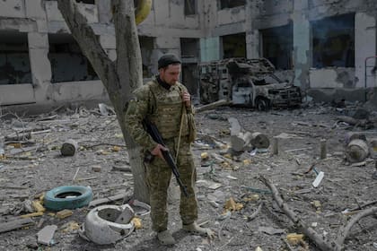 Un soldado ucraniano frente a una escuela alcanzada por cohetes rusos en la aldea de Zelenyi Hai, en el sur de Ucrania
