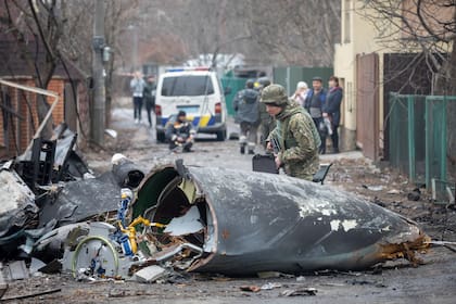 Un soldado ucraniano inspecciona los restos de un avión derribado en Kiev