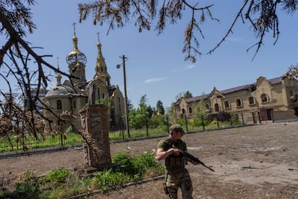 Un soldado ucraniano patrulla un pueblo cerca del frente de batalla en la región de Donetsk. (AP Photo/Bernat Armangue)
