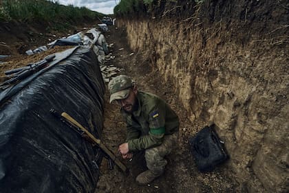 Un soldado ucraniano se sienta en una trinchera en el frente cerca de Bakhmut, en la región de Donetsk, Ucrania, el lunes 22 de mayo de 2023.