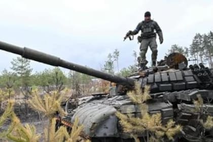 Un soldado ucraniano sobre un tanque ruso destruido a las afueras de Kiev