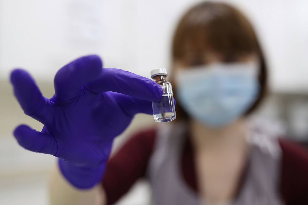 Un técnico de farmacia del NHS sostiene un vial mientras simula la preparación de la vacuna contra el coronavirus de Pfizer-BioNTech, durante una sesión de capacitación del personal antes del lanzamiento de la vacuna, mañana, en el Royal Free Hospital de Londres