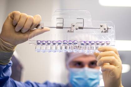 Un técnico de laboratorio inspecciona viales llenos de la vacuna de Pfizer para el Covid-19 en las instalaciones de la compañía en Puurs, Bélgica.  (Pfizer vía AP)