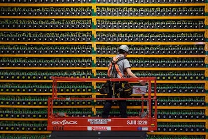 Un técnico inspecciona las computadoras dedicadas a "minar" bitcoin, es decir a realizar los procesos informáticos que reciben a cambio un pago en bitcoin