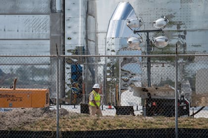 Un trabajador camina por la base de un prototipo de nave espacial Starship de SpaceX en las instalaciones de lanzamiento de la compañía en Texas