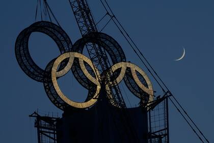 Un trabajador coloca los aros olímpicos en una torre a las afueras de Beijing, el miércoles 5 de enero de 2022 (AP Foto/Ng Han Guan)