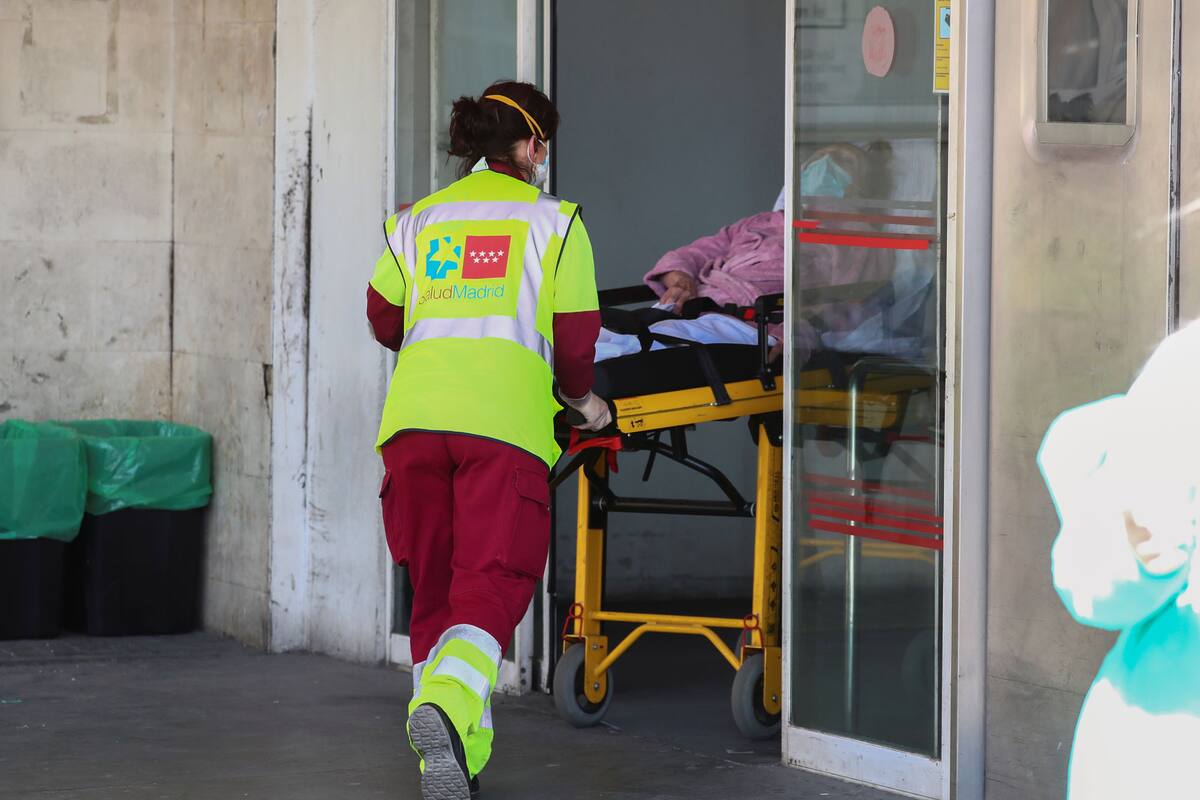 Un trabajador de la salud con una máscara facial protectora transporta a un paciente a la unidad de emergencia en el hospital 12 de Octubre durante el brote de la enfermedad por coronavirus (COVID-19) en Madrid