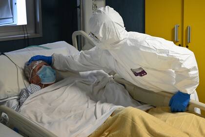 Un trabajador de la salud cuida a un paciente en la unidad de cuidados intensivos en el hospital San Filippo Neri en Roma, el 20 de abril de 2020, durante la cuarentena nacional destinada a detener la propagación del coronavirus