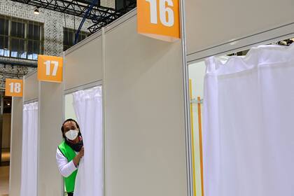 Un trabajador de la salud mira desde una cabina en un nuevo centro de vacunación en el antiguo aeropuerto de Tempelhof en Berlín el 8 de marzo de 2021, en medio de la nueva pandemia de coronavirus