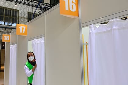 Un trabajador de la salud mira desde una cabina en un nuevo centro de vacunación en el antiguo aeropuerto de Tempelhof en Berlín el 8 de marzo de 2021, en medio de la nueva pandemia de coronavirus