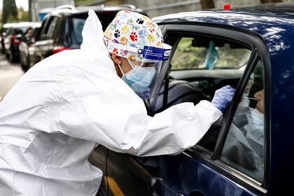 Un trabajador de la salud realiza pruebas a los automovilistas, en Roma