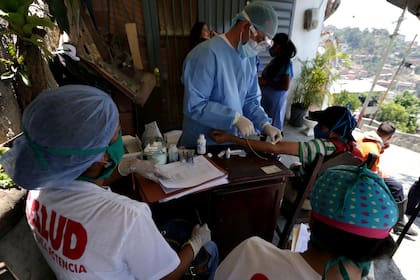 Un trabajador de la salud realiza una prueba rápida para la enfermedad causada por el nuevo coronavirus durante una jornada de salud preventiva, en el municipio de Carrizal, estado de Miranda, en Venezuela