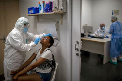 Un trabajador de salud toma una muestra para una prueba de PCR para el COVID-19 en un hospital local en Hospitalet, en las afueras de Barcelona, España.