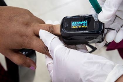Un trabajador de salud utiliza un oxímetro de pulso para determinar el nivel de saturación de oxígeno en un paciente, en un hospital en Gauhati, India, 21 de enero de 2021. (AP Foto/Anupam Nath, File)
