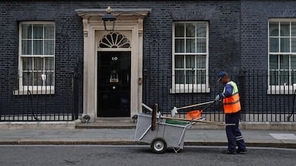 Un trabajador de Westminster limpia Downing Street a la altura de la residencia oficial de la primera ministra Theresa May; todos los ojos están puestos en qué pasará tras las elecciones