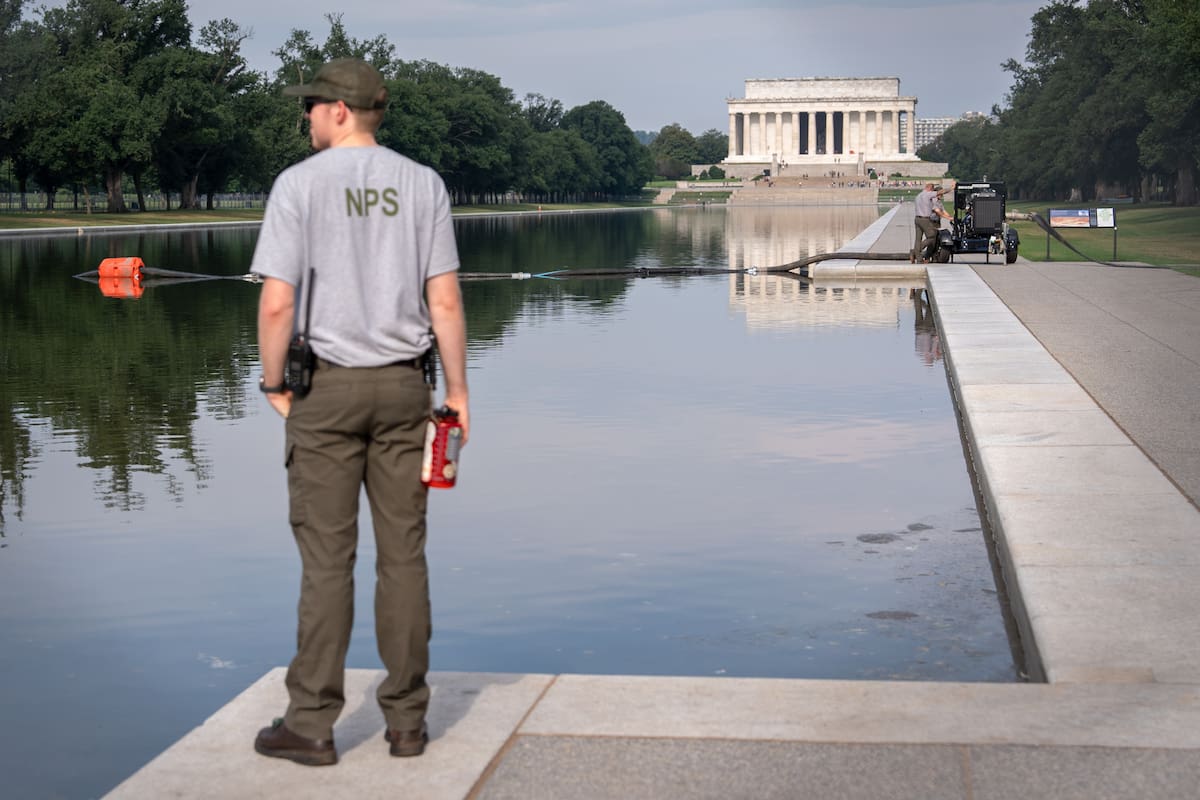 Un trabajador del Servicio de Parques Nacionales observa cerca del Estanque Reflectante Conmemorativ