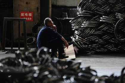 Un trabajador descansa en una fábrica de aros de acero para ruedas de bicicleta a exportar a Estados Unidos en Hangzhou