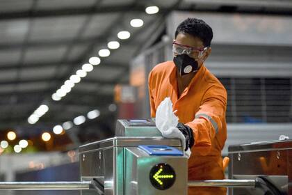 Un trabajador desinfecta una estación de autobuses, como medida preventiva frente a la pandemia mundial de coronavirus COVID-19, en Cali, Colombia,
