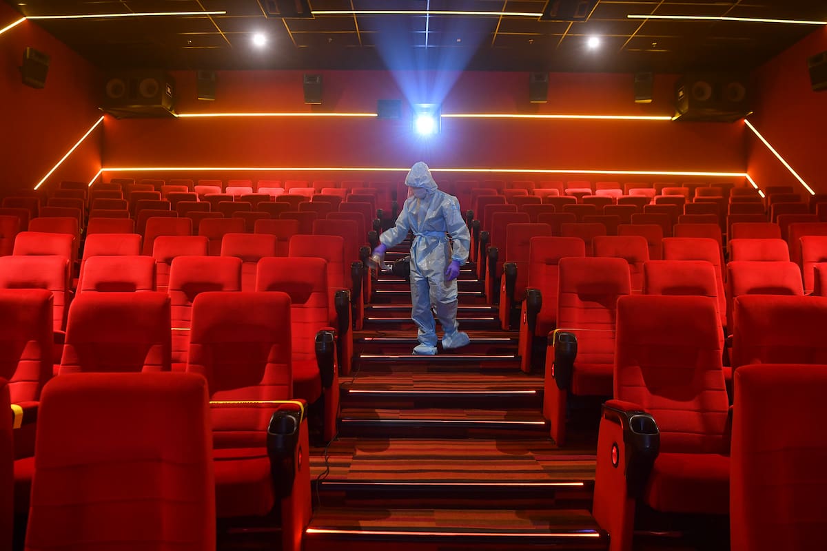 Un trabajador desinfecta una sala de teatro antes de la reapertura programada de las salas de cine el 15 de octubre en Mumbai