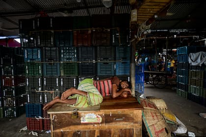 Un trabajador duerme en el mercado mayorista más grande de Dhaka el 6 de agosto de 2020