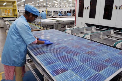 Un trabajador elabora un tablero solar en una fábrica en las afueras de Hyderabad, India, el miércoles 25 de enero de 2023. (AP Foto/Mahesh Kumar A.)