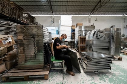 Un trabajador en una pequeña fábrica que produce electrodomésticos para restaurantes en Guangzhou, China (Qilai Shen/The New York Times)