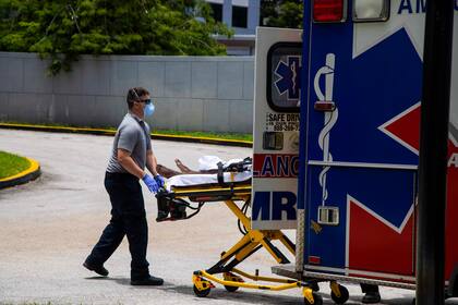 Un trabajador médico traslada a un paciente al Jackson Memorial Hospital en Miami
