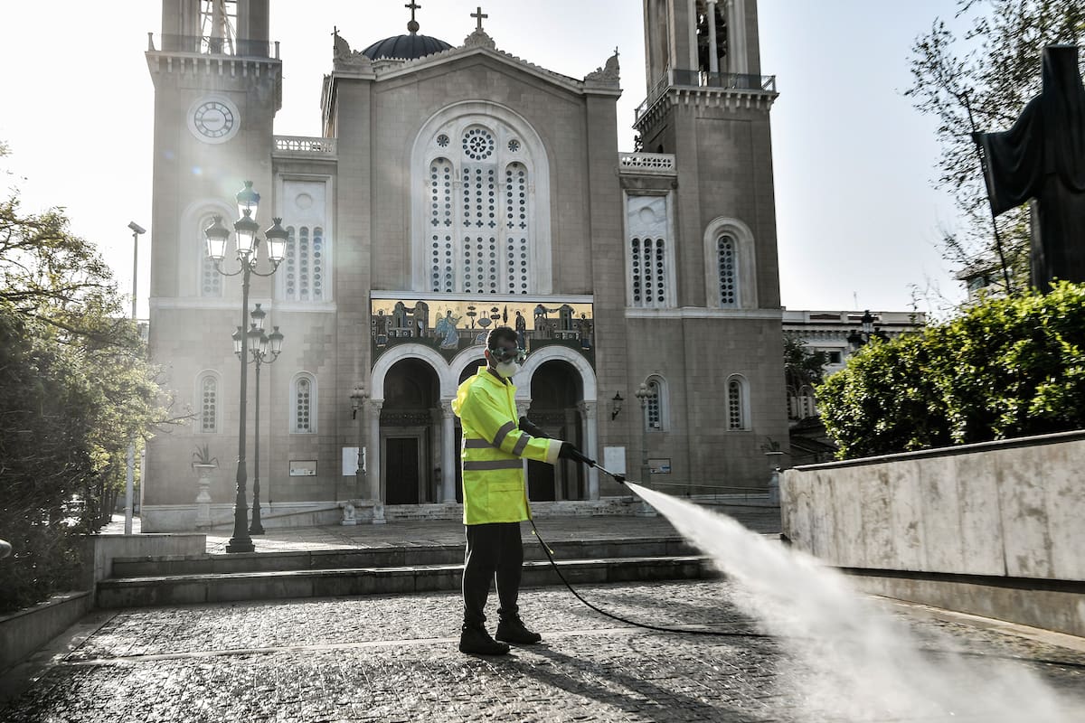Un trabajador municipal desinfecta la explanada frente a la Iglesia Metropolitana de Atenas el 15 de abril de 2020, mientras el país permanece bajo cuarentena para detener la propagación de la pandemia de coronavirus