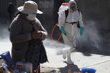 Un trabajador sanitario desinfecta un mercado en Perù