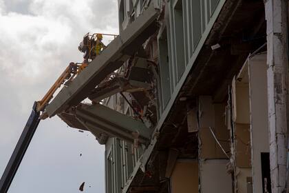 Un trabajador retira parte de la fachada dañada en el lugar de una explosión mortal que destruyó el Hotel Saratoga de cinco estrellas en La Habana Vieja, Cuba, el domingo 8 de mayo de 2022. (AP Foto/Ismael Francisco)