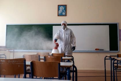 Un trabajador rocía desinfectante en un aula en Ioannina, Grecia