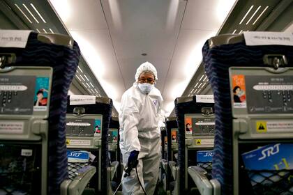 Un trabajador rocía desinfectante en un tren en Seúl, Corea
