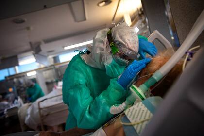 Un trabajador sanitario atiende a un paciente con coronavirus en la Unidad de Cuidados Intensivos del Hospital Povisa en Vigo, noroeste de España, el 16 de abril de 2020
