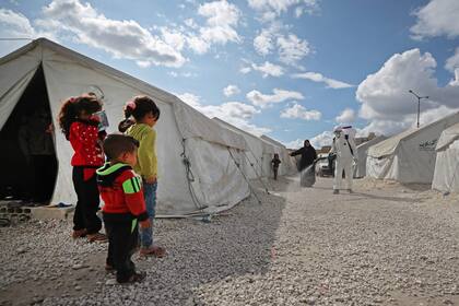 Un trabajador sanitario desinfecta un campamento cerca de Idlib, en Siria