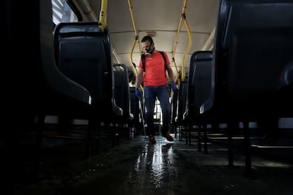 Un trabajador sanitario desinfecta un colectivo en San José, Costa Rica