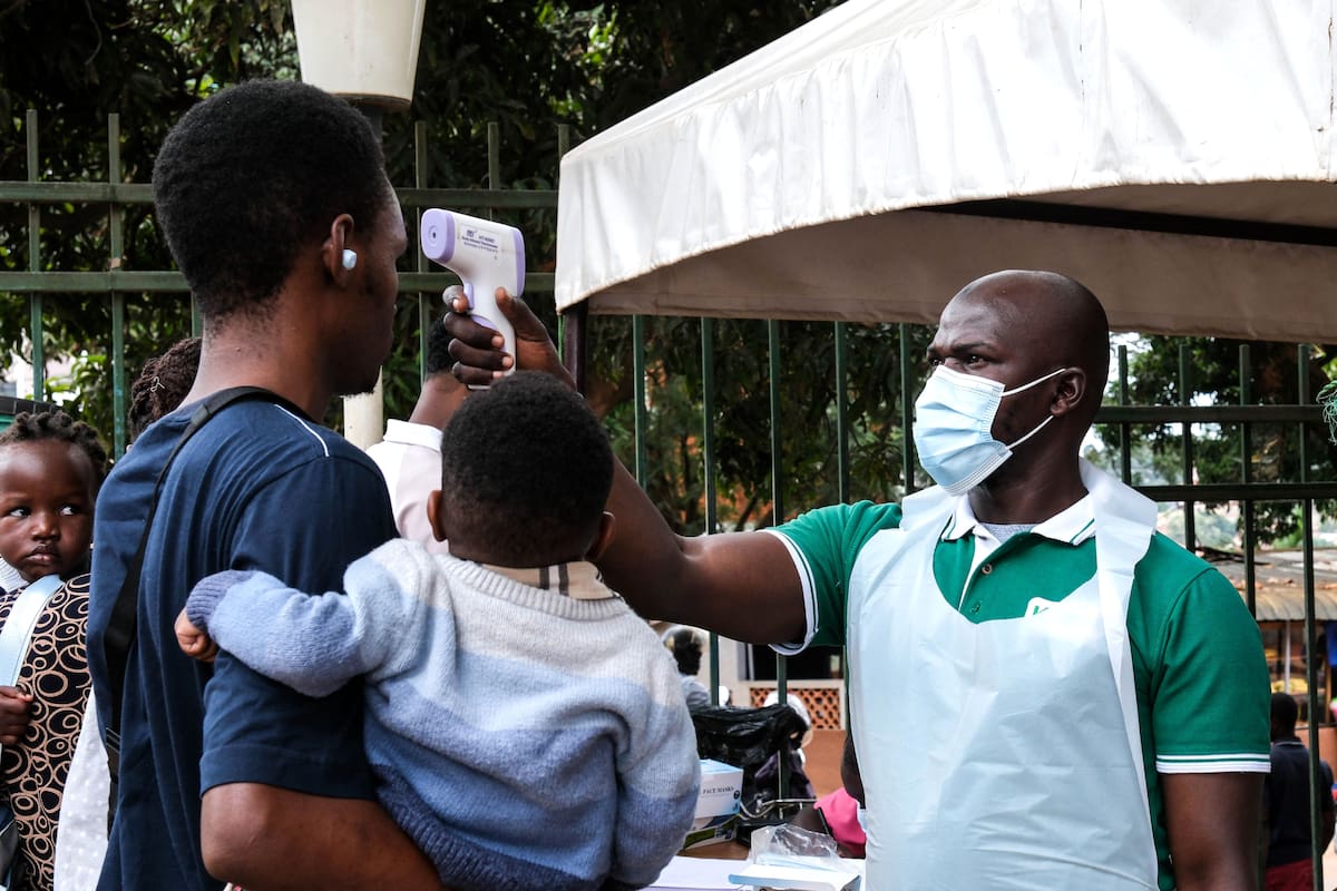 Un trabajador sanitario usa un termómetro para revisar la temperatura de las personas frente al Hospital Musulmán Kibuli en Kampala, Uganda, el sábado 16 de mayo de 2026. (AP Foto/ Hajarah Nalwadda)
