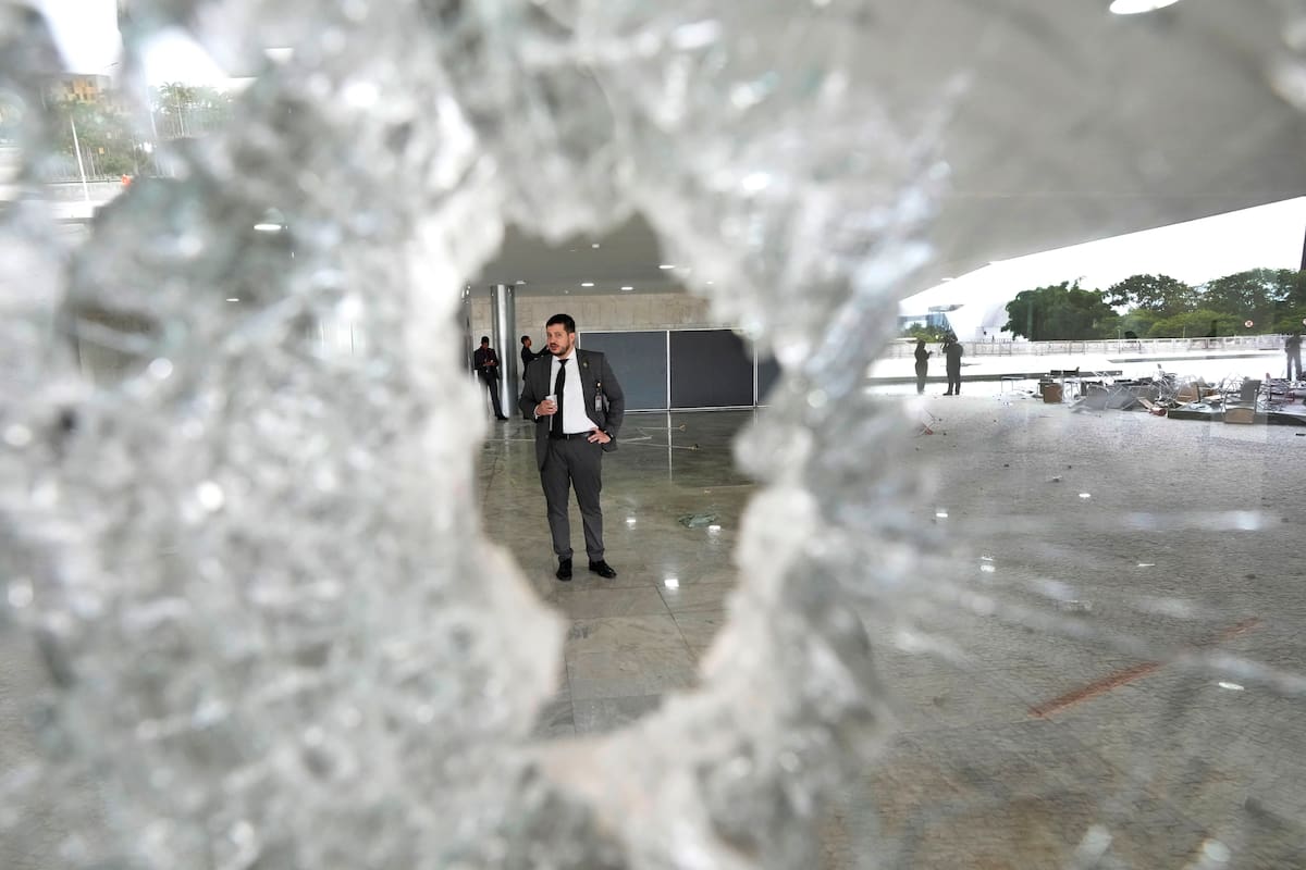Un trabajador se para al otro lado de una ventana rota en el Palacio de Planalto el día después de que la oficina del presidente fuera asaltada por partidarios del expresidente brasileño Jair Bolsonaro en Brasilia