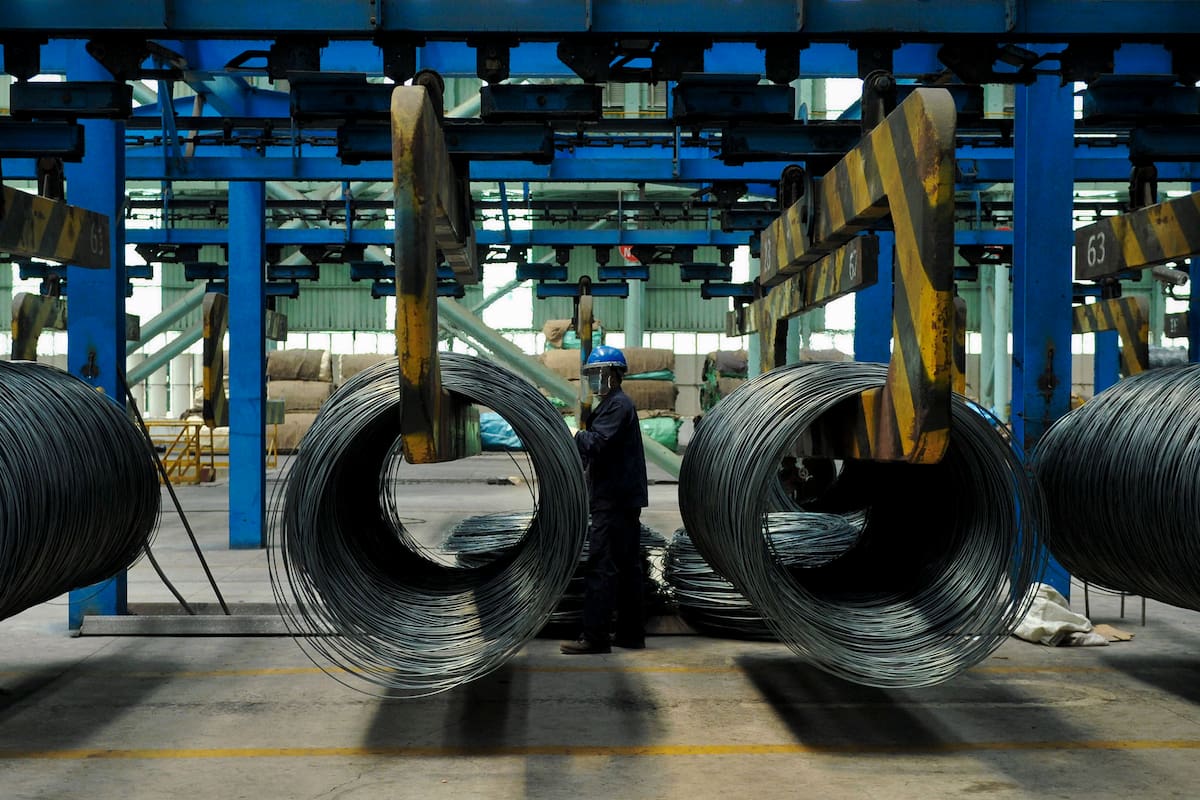 Un trabajador traslada cables de acero en una fábrica