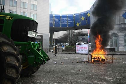 Un tractor y el fuego frente al Parlamento Europeo reflejaron la protesta de agricultores