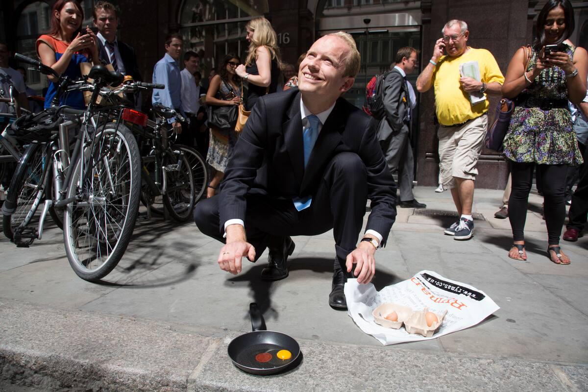 Un transeúnte trata de freír un huevo durante su hora de almuerzo