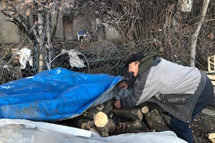 Un vecino de Laguna Blanca protege la leña con un nylon para que no se moje