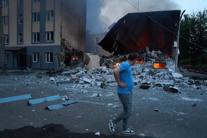 Un vecino pasa junto a restos humeantes tras un ataque ruso con drones y misiles en Kiev