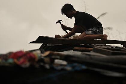 Un vecino refuerza su tejado en Santa Ana, provincia de Cagayán, en el norte de Filipinas, antes de la llegada del tifón Usagi el jueves 14 de noviembre de 2024. (AP Foto/Noel Celis)