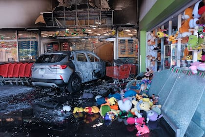 Un vehículo calcinado permanece en un supermercado dañado en Guadalajara, Jalisco, México, el domingo 22 de febrero de 2026