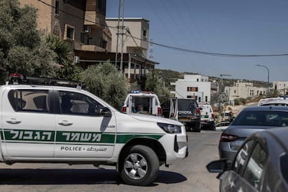 Un vehículo de la policía fronteriza israelí bloquea una calle en la ciudad árabe de Tayibe mientras las fuerzas de seguridad registran la zona tras los múltiples ataques