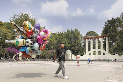 Un vendedor de globos en el Parque México, en la colonia Condesa, con el Foro Lindbergh al fondo.