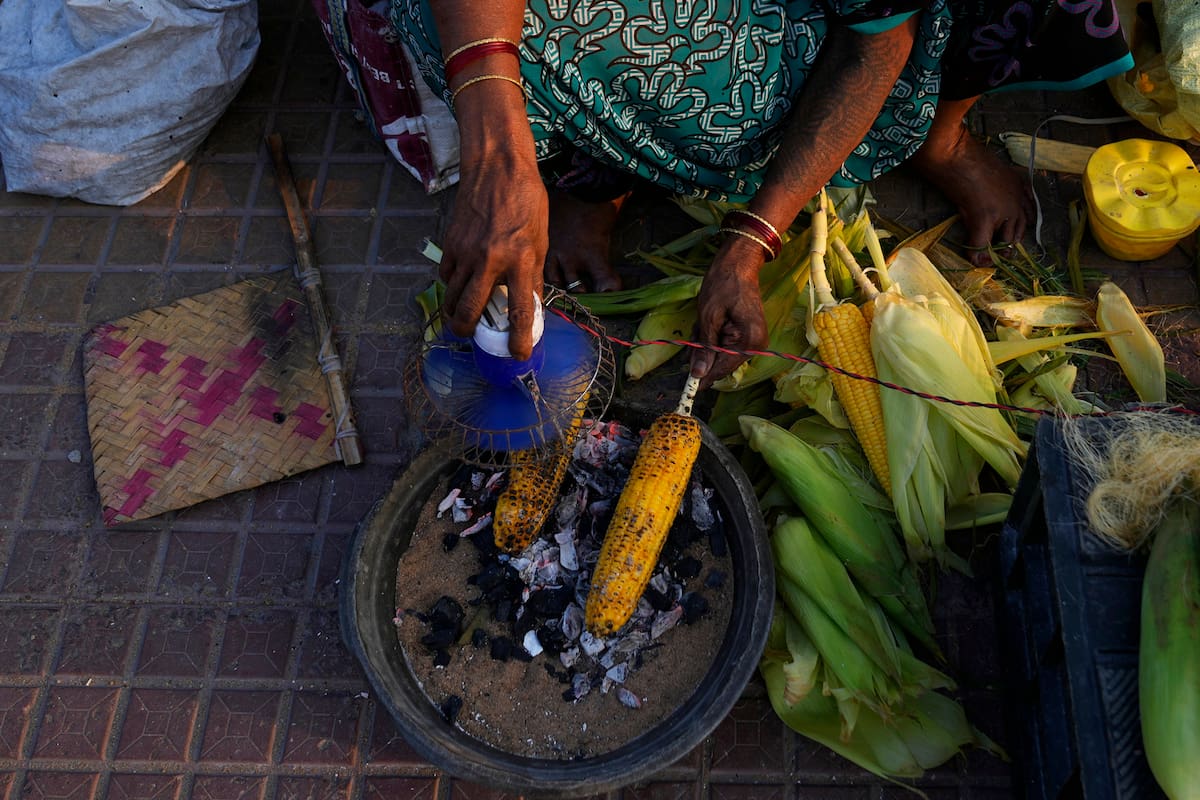 Un vendedor prepara maíz dulce en Visakhapatnam, India; edición fotográfica de Jesica Rizzo