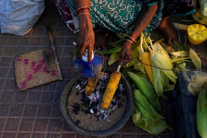 Un vendedor prepara maíz dulce en Visakhapatnam, India; edición fotográfica de Jesica Rizzo
