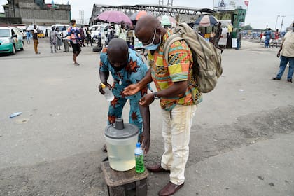 Un viajero desinfecta sus manos en cumplimiento de las medidas en la terminal de autobuses para reducir la propagación del coronavirus en Lagos, NIgeria, el 1 de julio de 2020